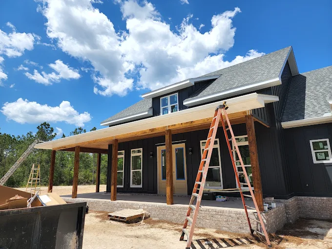 Gutter installation underway on a new construction home with a covered outdoor area.