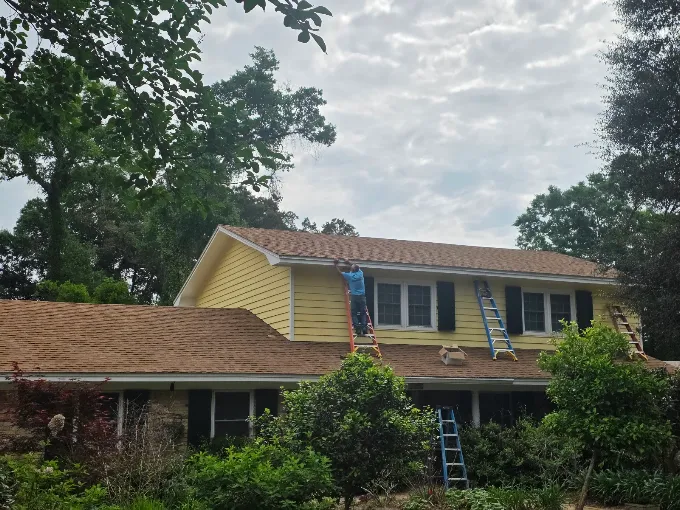 Gutter work in progress along the upper roofline of a two-story home.